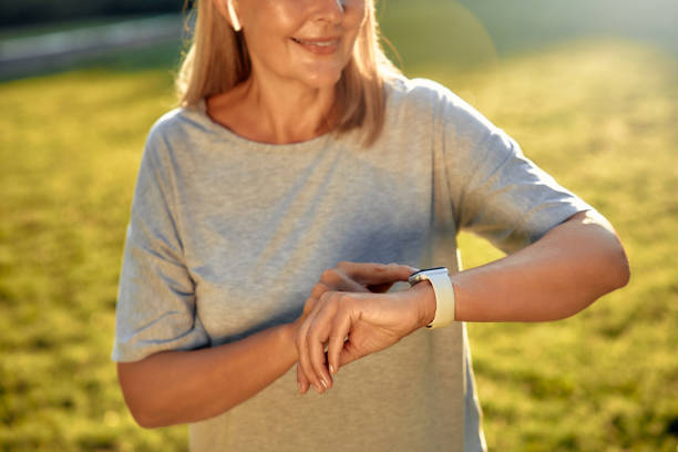 istock A Woman is Checking Her Smartwatch While Relaxing in a Sunlit Park on a Beautiful Day 2177801820