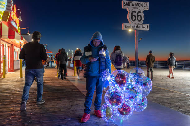 Cabo San Lucas, Mexico - December 25, 2023: A Mexican man sells cotton candy along the Playa Pública public beach at the resort city of Cabo San Lucas, Mexico. Cabo San Lucas, a resort city on the southern tip of Mexico’s Baja California peninsula, is known for its beaches, water-based activities and nightlife.