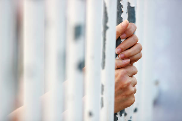 istock Hands Holding onto Metal Bars in a Captive Context 2177810116
