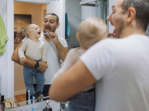 istock Young father brushing his son's teeth at bathroom 2177813796