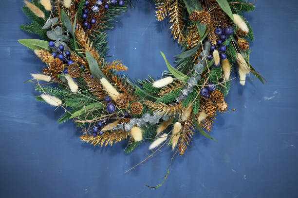 istock Christmas pine needle wreath with blue berries on a blue background 2177819365