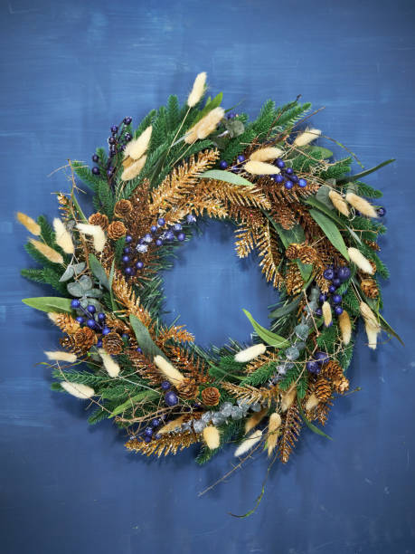 istock Christmas pine needle wreath with blue berries on a blue background 2177819366