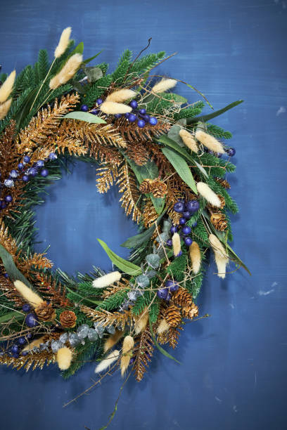 istock Christmas pine needle wreath with blue berries on a blue background 2177819379