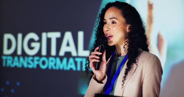 istock Stage, presenter and woman at seminar with microphone, tablet and presentation on digital transformation. Ideas, change and speaker at conference on future business development plan with technology 2177825908