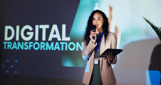 istock Stage, speaker and woman at seminar with microphone, tablet and presentation on digital transformation. Ideas, change and presenter at conference on future business development plan with technology 2177825916