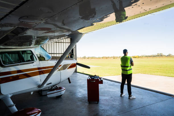 Aeronautical mechanic looking away at airplane hangar