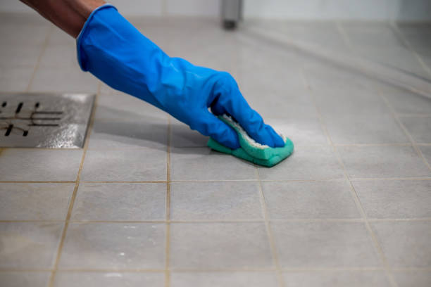 istock Tile floor was partially washed. Hand in blue gloves cleaning tile floor with sponge. 2177833176
