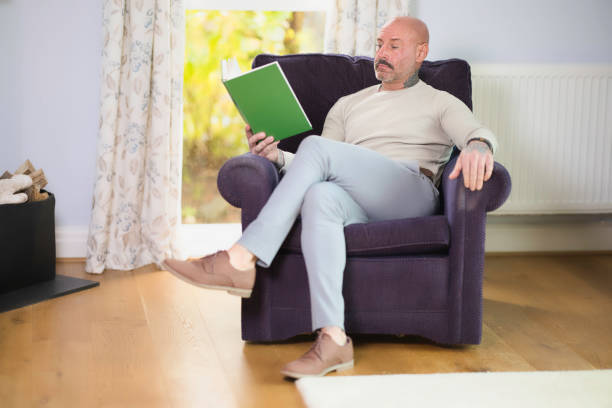 istock Middle aged man relaxing at home with a book 2177835937