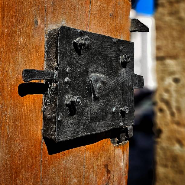 An extreme close-up vertical shot of an old metal door handle.