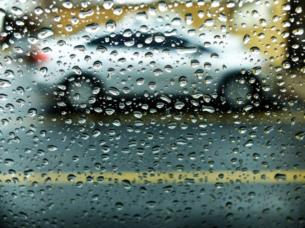 istock Raindrops on Glass Window Looking into Street with Car 2177841792