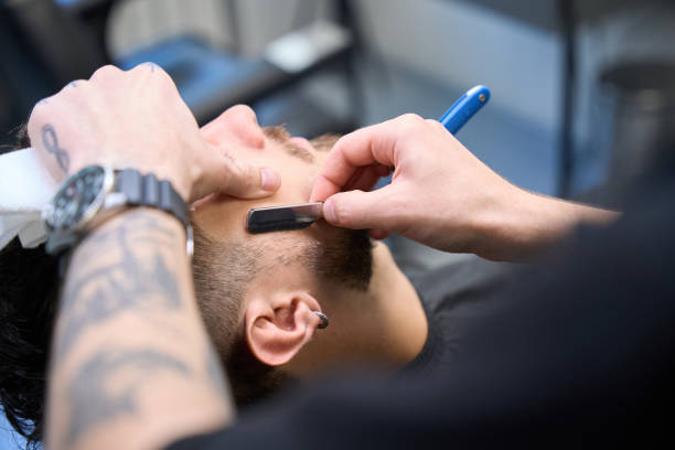 istock Grooming expert shapes beard with small blade 2177842706
