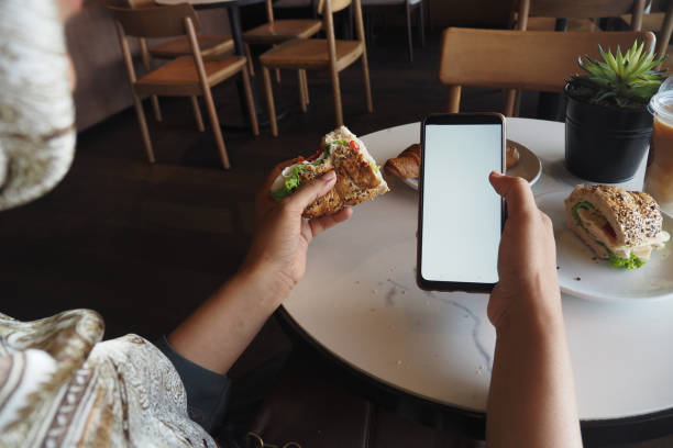 istock Delicious Sandwich with Smartphone in a Cozy Caf Setting 2177844649