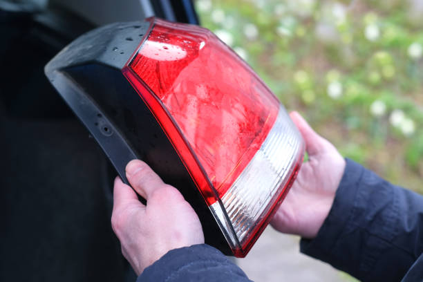 istock car rear lights, close-up male hands install red and white rear view advanced head-lights on black automobile, replace the taillight lamps, sale and purchase of spare parts 2177846331