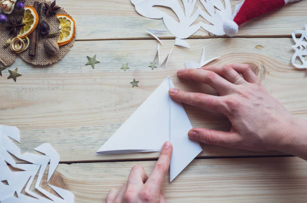 istock A snowflake made from paper with your own hands gracefully decorates a winter interior, adding warmth and a cozy atmosphere 2177849628