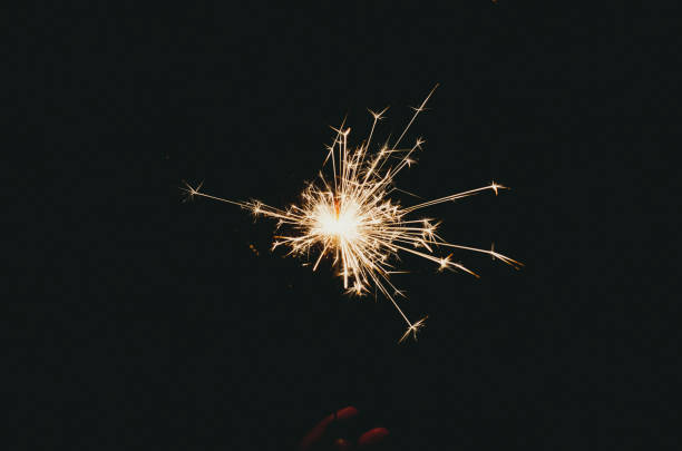 Sparklers sparkle brightly against a black background, creating the effect of magic and celebration, filling the atmosphere with joy.