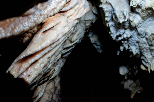 Close-up on the limestone formations formed over time in the depths of a cave in Piedmont