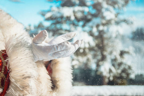 Santa hands in white gloves Praying for good and peace in the World. Unknown senior open palm hands in Winter nature. Copy space Copy space