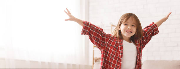 istock Smiling little girl raising hands up, having fun 2177853870