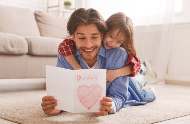 istock Emotional dad reading greeting card while bonding with daughter 2177853874