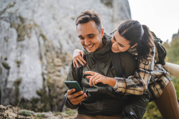 istock Girlfriend hug boyfriend while he use mobile phone on hiking 2177856614