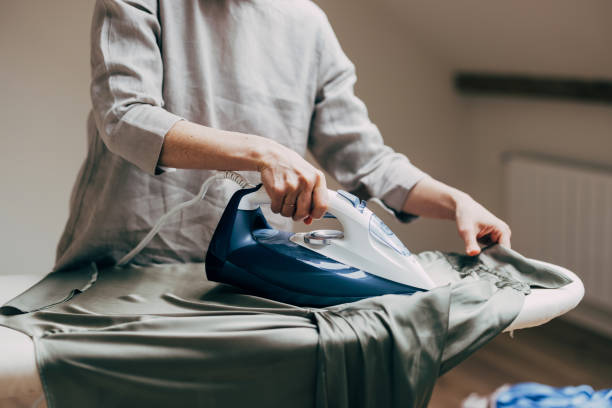 Person Ironing Clothes on an Ironing Board in a Cozy Room