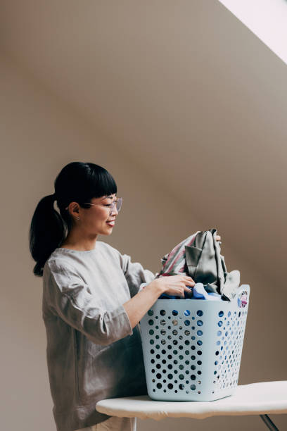 istock Woman Sorting Laundry in a Bright Attic Room Setting 2177864471