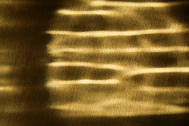 abstract texture in gold with dark pattern. table background with golden sun shadow