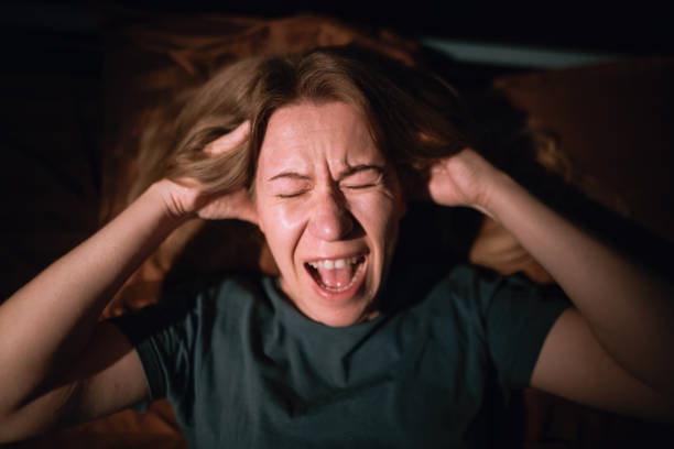 istock woman at night having anxiety and screaming while having nightmares, sleep disorder and panic attack 2177874920