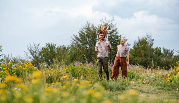 istock Happy Family Stroll Through a Vibrant Meadow on a Sunny Day 2177876019