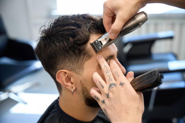 istock Worker modeling hairstyle with clipper, creating stylish haircut 2177876094