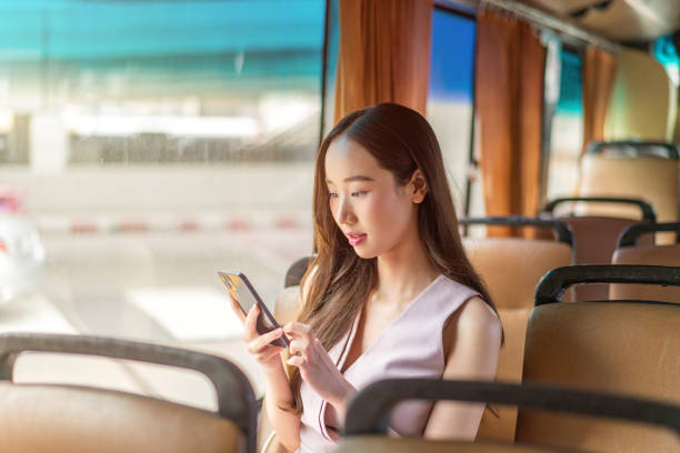 istock Asian Woman Using Smartphone While Seated on a Bus 2177880099