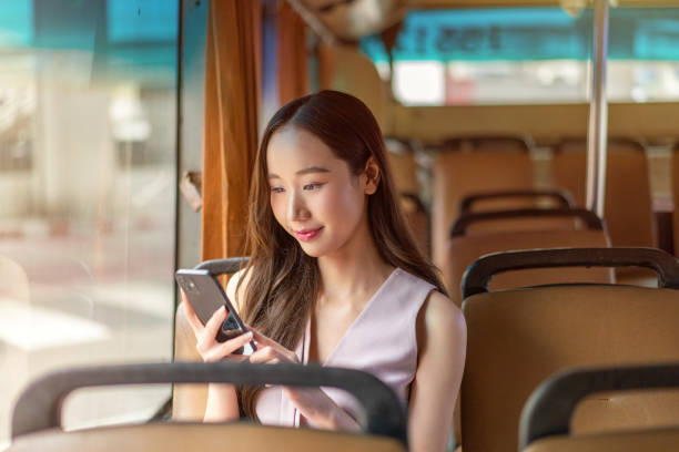 istock Asian Woman Using Smartphone While Seated on a Bus 2177880105