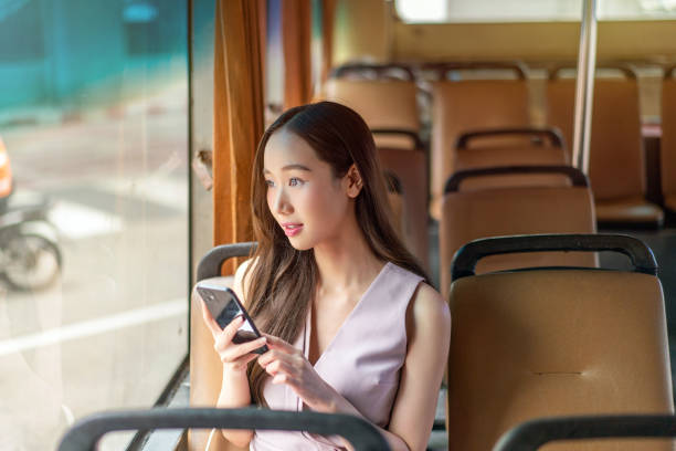 istock Asian Woman Using Smartphone While Seated on a Bus 2177880919