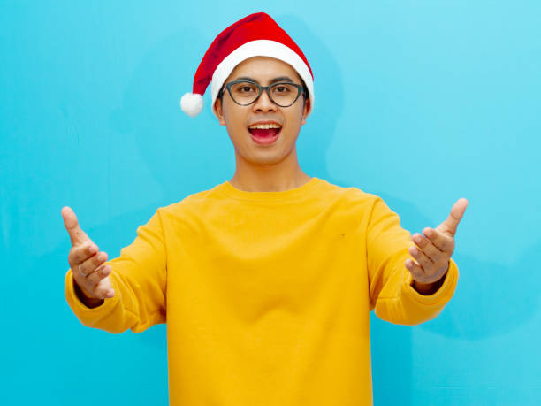 istock Asian man wearing a Christmas hat standing with a surprised expression on an isolated background. 2177882807