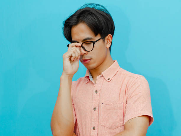 istock Feeling stressed. Frustrated young man touching his head and keeping eyes closed on isolated background 2177885164