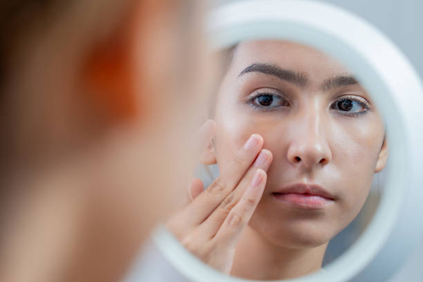 istock Woman examining skin in mirror 2177885222