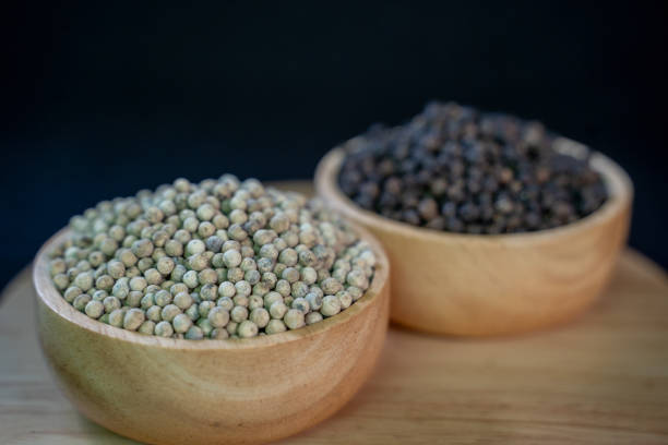Green fresh black pepper on wood texture.