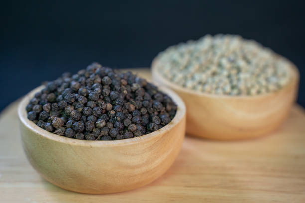 Pepper in wooden container on wooden background