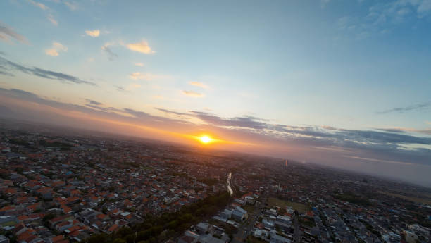 istock The sun is setting over a city with a river running through it 2177887804