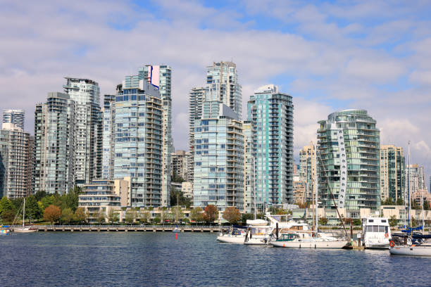 Postcard like closeup of False Creek's north side as seen from across harbor waters in front of Vancouver's Charleson Park on the Island Park Seawall pedestrian footpath.