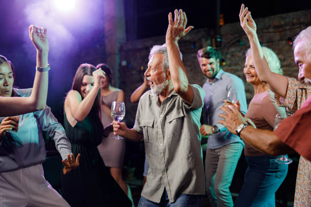 istock Carefree seniors and young people dancing in a disco. 2177903176