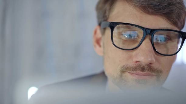 istock Businessman with glasses looking intently obscured partially by a translucent surface of laptop. Business concept 2177905455