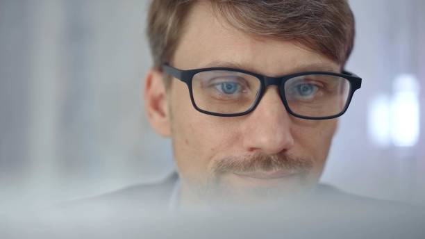 istock Businessman with glasses looking intently obscured partially by a translucent surface of laptop. Business concept 2177905624