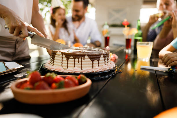 Close up of unrecognizable woman serving Birthday cake to her family.