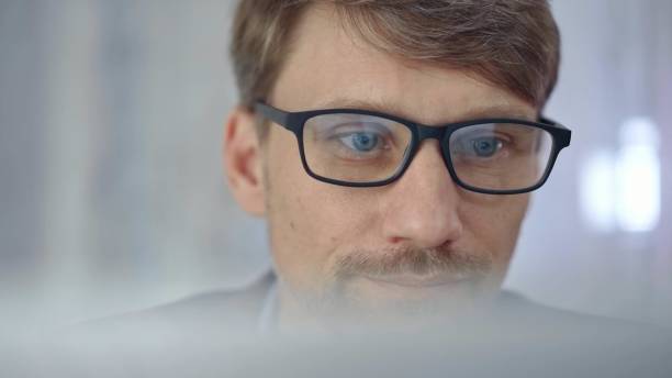 istock Businessman with glasses looking intently obscured partially by a translucent surface of laptop. Business people concept 2177906611