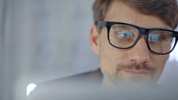 istock Businessman with glasses looking intently obscured partially by a translucent surface of laptop. Business people concept 2177906734