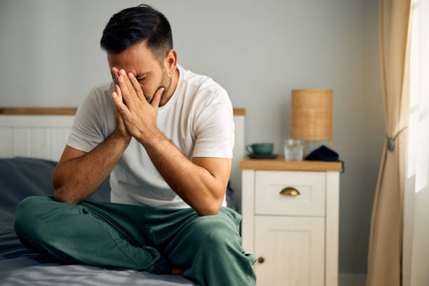 istock Depressed man sitting on bed in the morning. 2177911495