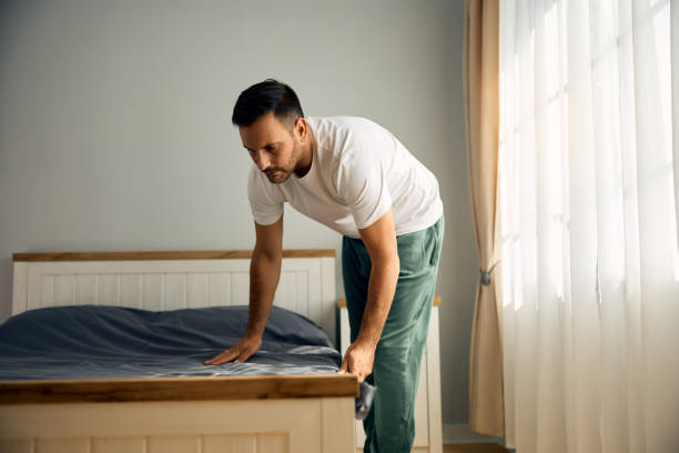 istock Man in pajama making his bed in the morning. 2177911531