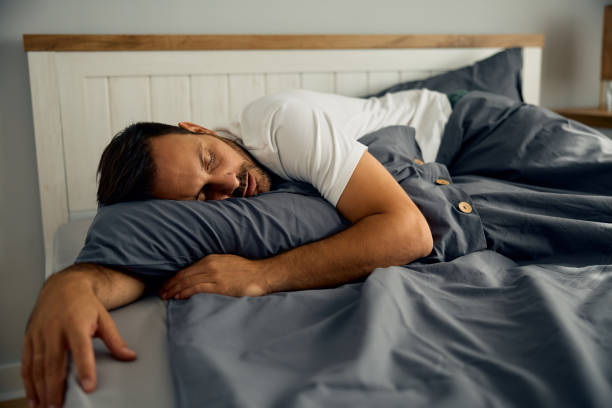 istock Mid adult man sleeping in bedroom. 2177911599