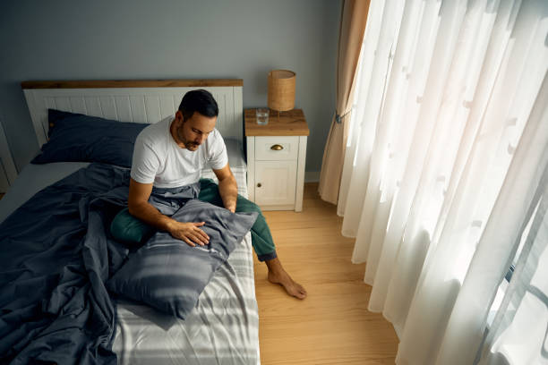 istock Sad man in pajama dealing with morning depression in bedroom. 2177911604